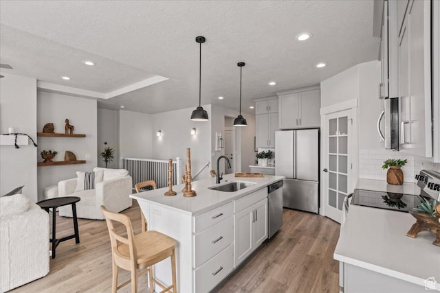 6079 W Teton Village Dr Unit 106, Herriman, UT 84096 - kitchen with stainless steel appliances, light countertops, a sink, light wood-style floors, and open floor plan