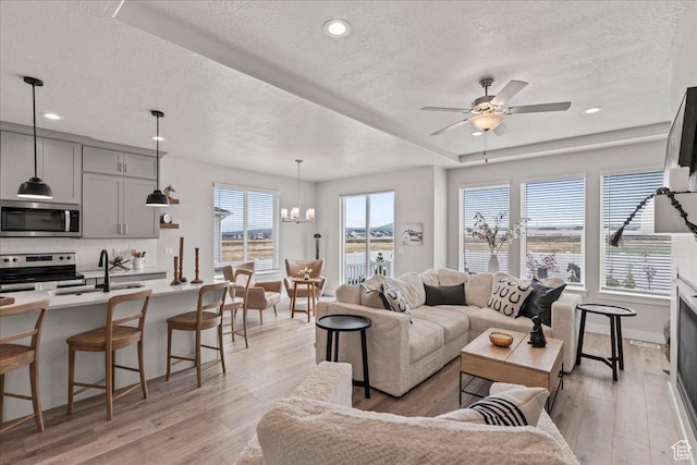 6079 W Teton Village Dr Unit 106, Herriman, UT 84096 - living area featuring recessed lighting, light wood-style floors, a textured ceiling, and ceiling fan with notable chandelier