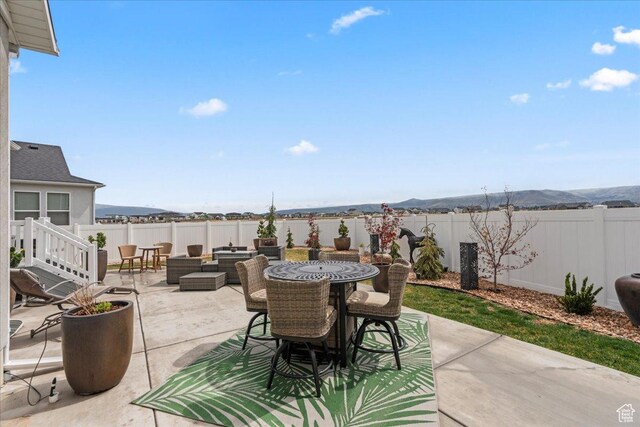 6079 W Teton Village Dr Unit 106, Herriman, UT 84096 - view of patio / terrace featuring a fenced backyard, outdoor dining space, and a mountain view