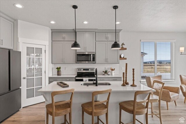 6079 W Teton Village Dr Unit 106, Herriman, UT 84096 - kitchen with a sink, a textured ceiling, gray cabinets, light countertops, and appliances with stainless steel finishes
