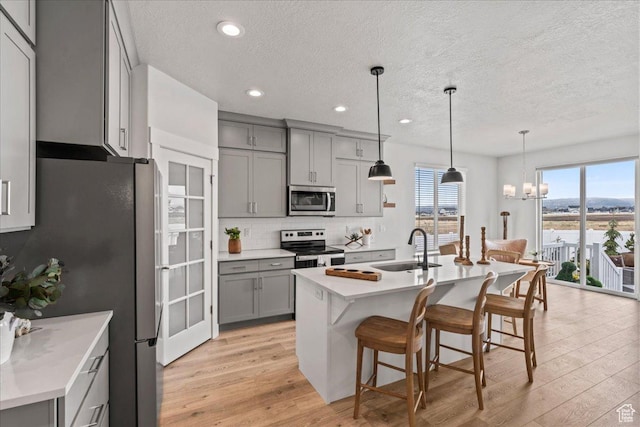 6079 W Teton Village Dr Unit 106, Herriman, UT 84096 - kitchen with a sink, gray cabinetry, a textured ceiling, and appliances with stainless steel finishes