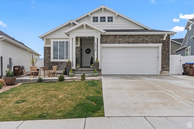 craftsman-style home with a front lawn, stone siding, concrete driveway, fence, and an attached garage