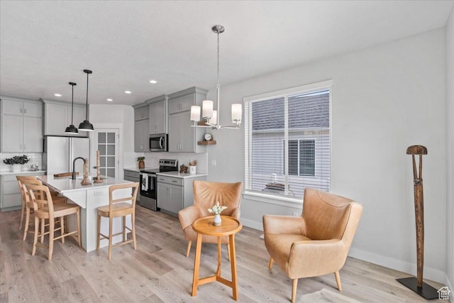 6079 W Teton Village Dr Unit 106, Herriman, UT 84096 - kitchen with stainless steel appliances, backsplash, a breakfast bar area, and gray cabinets