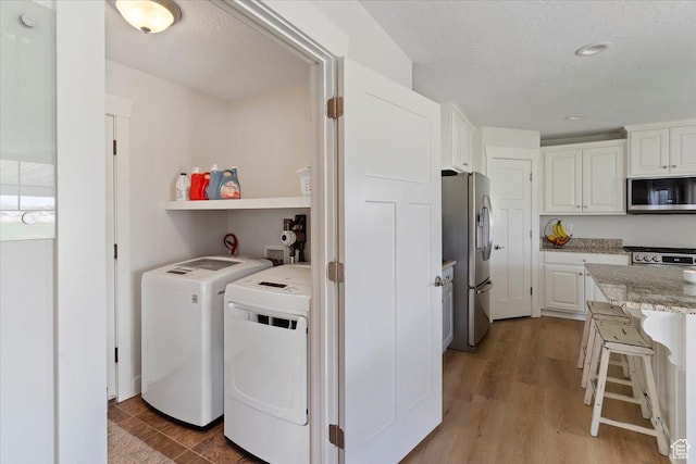 2292 W 440 S, Provo, UT 84601 - washroom with washer and dryer, light wood finished floors, a textured ceiling, and laundry area