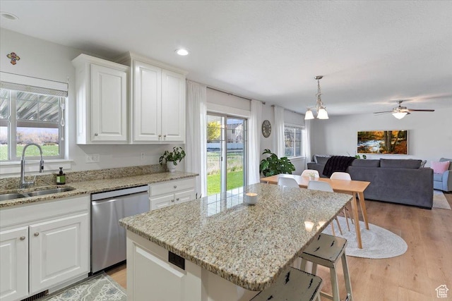2292 W 440 S, Provo, UT 84601 - kitchen featuring a sink, a breakfast bar area, dishwasher, light wood-type flooring, and white cabinetry