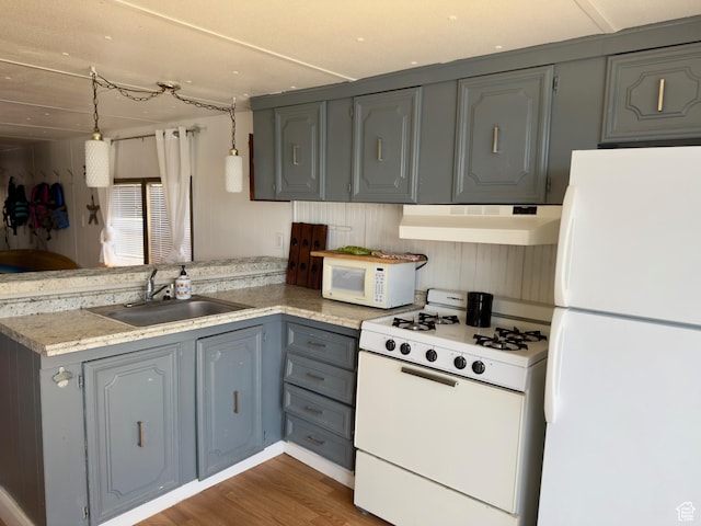 2904 S Edgemont Dr, Garden City, UT 84028 - kitchen with white appliances, under cabinet range hood, a peninsula, and gray cabinets