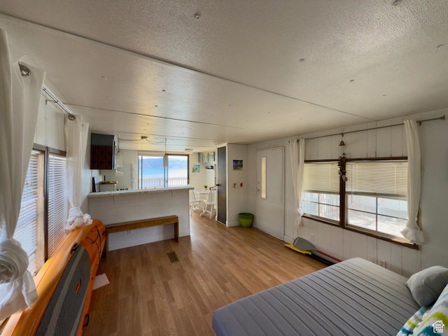 2904 S Edgemont Dr, Garden City, UT 84028 - bedroom with a textured ceiling, wood finished floors, and freestanding refrigerator