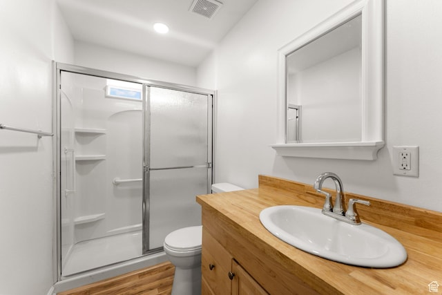 bathroom featuring a shower stall, visible vents, toilet, and wood finished floors