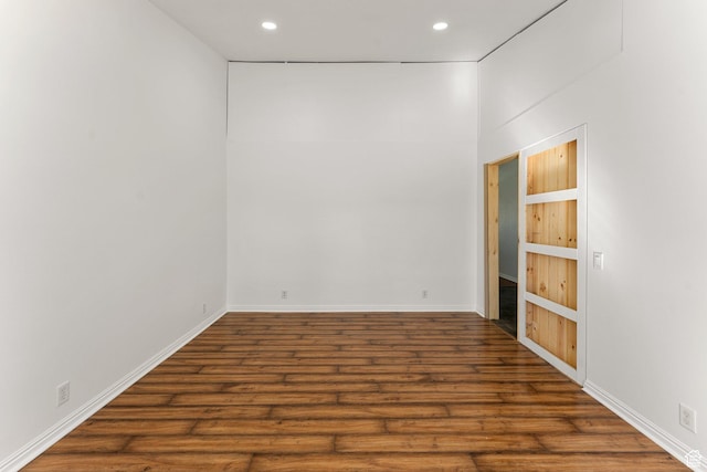 unfurnished room with recessed lighting, wood finished floors, and baseboards