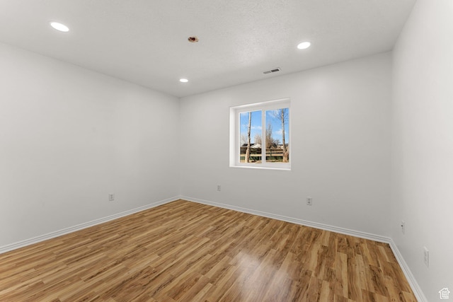 unfurnished room featuring recessed lighting, visible vents, light wood finished floors, and baseboards