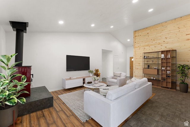 living room with lofted ceiling, a wood stove, wood finished floors, and recessed lighting