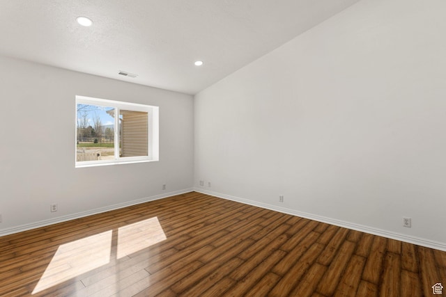 spare room featuring dark wood finished floors, baseboards, visible vents, and recessed lighting