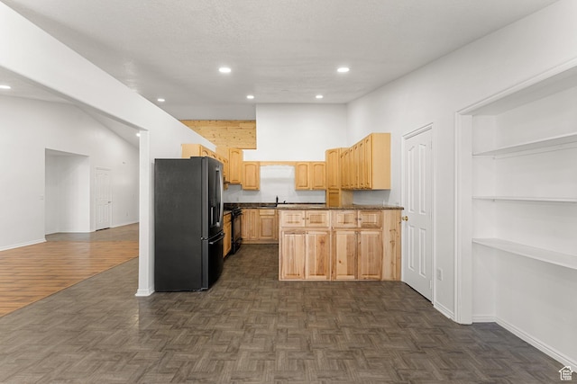 kitchen featuring dark countertops, light brown cabinets, baseboards, and stainless steel fridge with ice dispenser