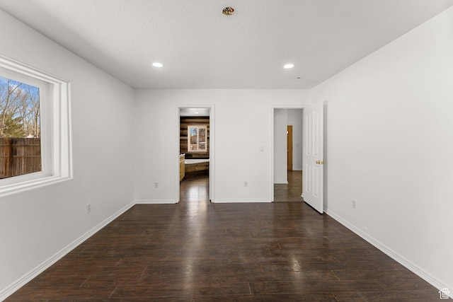 unfurnished room featuring baseboards, wood finished floors, and recessed lighting