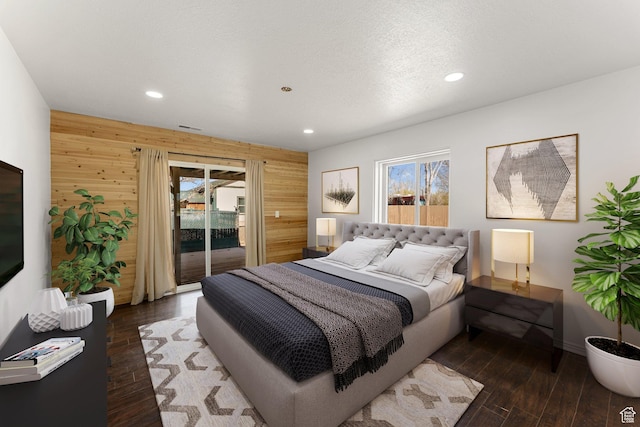 bedroom featuring access to outside, wood finished floors, wooden walls, and recessed lighting