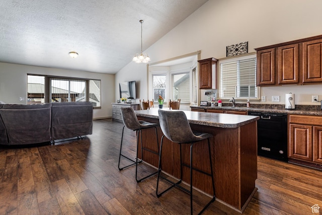 6576 W Oak Bridge Dr, West Jordan, UT 84081 - kitchen with black dishwasher, open floor plan, a chandelier, a breakfast bar, and dark countertops