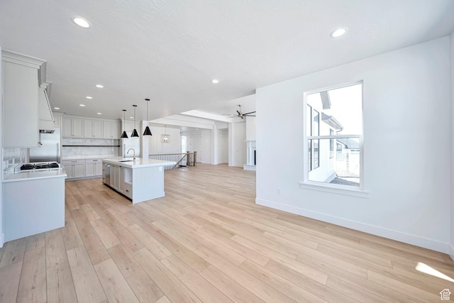 1910 W Bonneville Ln, Kaysville, UT 84037 - kitchen with a sink, tasteful backsplash, open floor plan, light countertops, and an island with sink