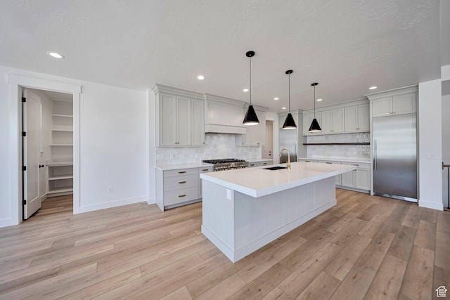 1910 W Bonneville Ln, Kaysville, UT 84037 - kitchen with light wood-style flooring, decorative backsplash, appliances with stainless steel finishes, light countertops, and a sink
