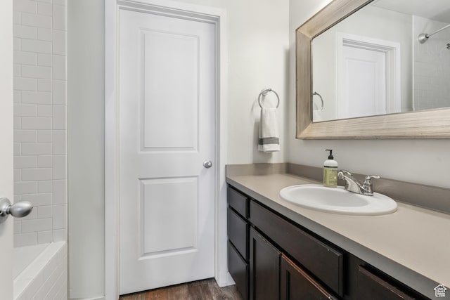 bathroom featuring vanity, wood finished floors, and tub / shower combination