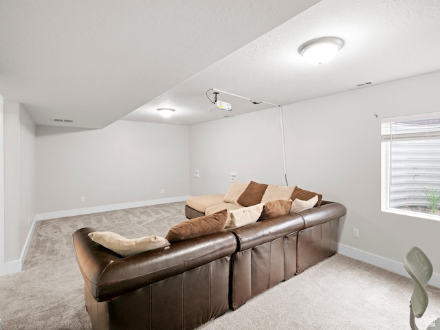 carpeted living area featuring a textured ceiling, visible vents, and baseboards