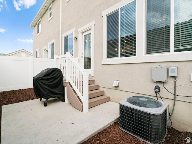 exterior space with cooling unit, area for grilling, and fence