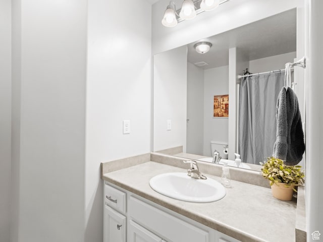 full bath with curtained shower, toilet, and vanity