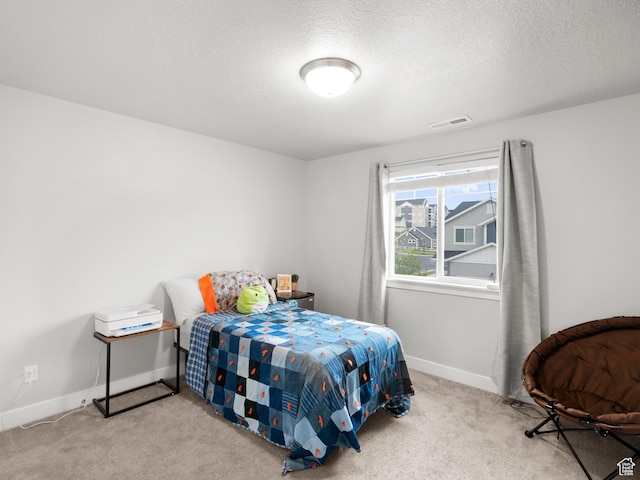 bedroom featuring carpet floors, a textured ceiling, visible vents, and baseboards