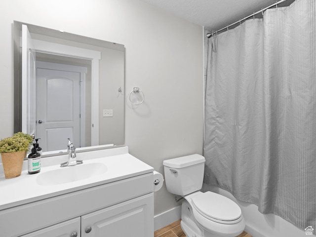 bathroom featuring shower / bath combo, toilet, baseboards, wood finished floors, and vanity