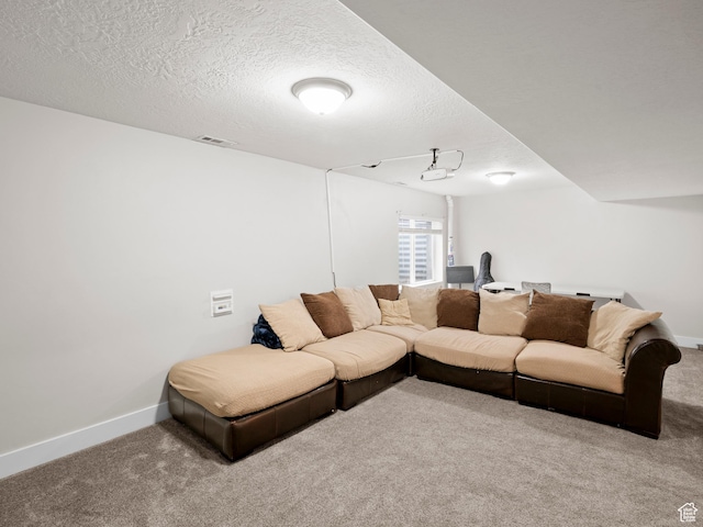 carpeted living area featuring baseboards, a textured ceiling, and visible vents