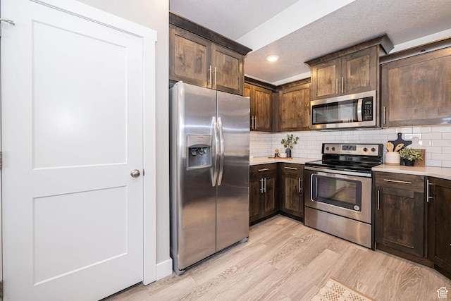 2276 W 2625 S Unit 110, West Haven, UT 84401 - kitchen featuring light wood finished floors, stainless steel appliances, light countertops, dark brown cabinets, and backsplash