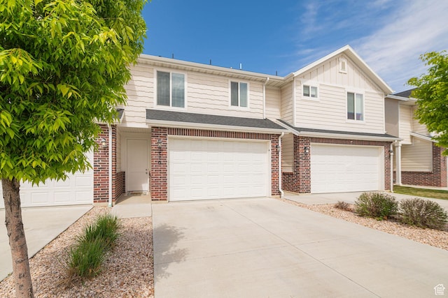 2276 W 2625 S Unit 110, West Haven, UT 84401 - view of property featuring board and batten siding, driveway, brick siding, and a garage