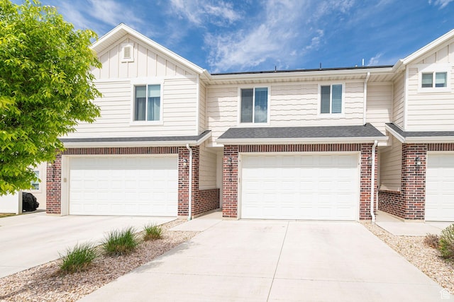 2276 W 2625 S Unit 110, West Haven, UT 84401 - townhome / multi-family property featuring concrete driveway, an attached garage, brick siding, and board and batten siding