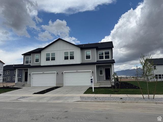 3651 N Oak Blvd Unit 337, Eagle Mountain, UT 84005 - view of front of house with board and batten siding, a garage, driveway, a mountain view, and a front lawn