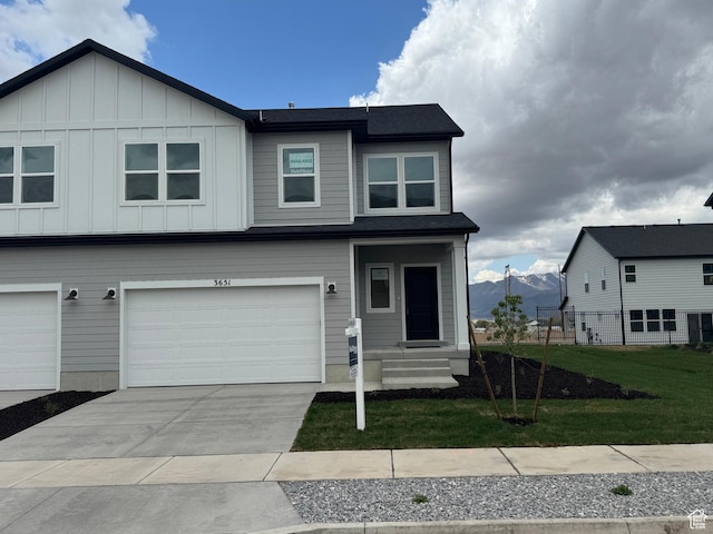 3651 N Oak Blvd Unit 337, Eagle Mountain, UT 84005 - view of front of home with concrete driveway, a front lawn, an attached garage, and board and batten siding