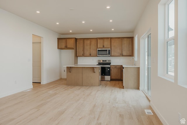 3651 N Oak Blvd Unit 337, Eagle Mountain, UT 84005 - kitchen featuring brown cabinets, stainless steel appliances, a kitchen island, and a sink