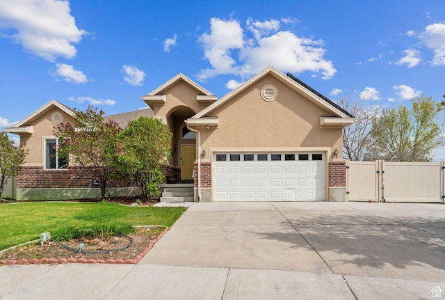 ranch-style house with a gate, concrete driveway, an attached garage, stucco siding, and a front yard