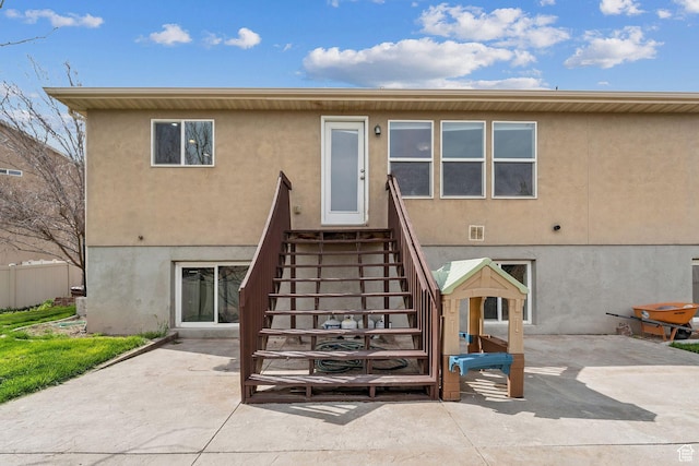 rear view of property with stucco siding and a patio area