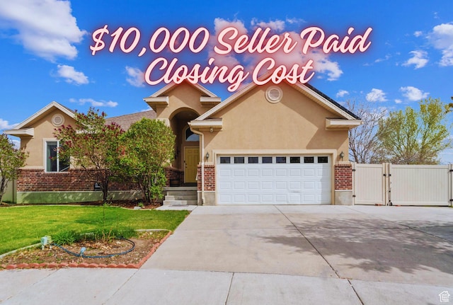 293 W Ann Cir N, Stansbury Park, UT 84074 - view of front facade with a gate, a front yard, stucco siding, and driveway