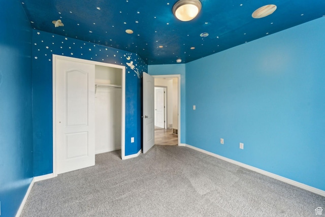 unfurnished bedroom featuring carpet, a closet, and baseboards