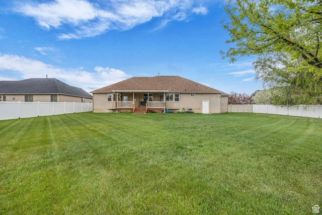 rear view of property with a lawn, a fenced backyard, and a deck