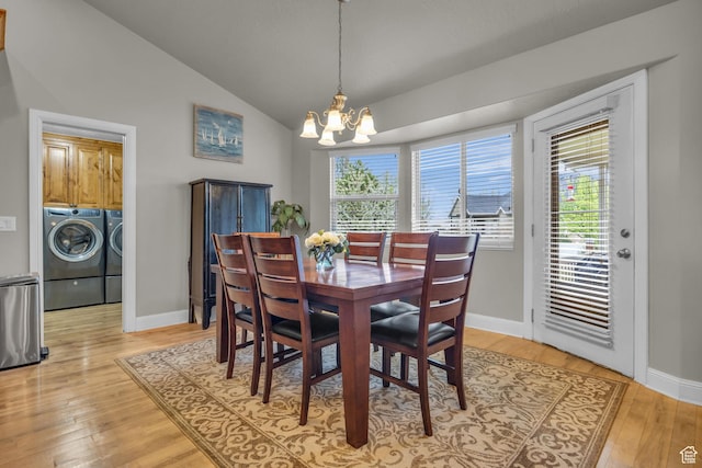 dining room featuring a chandelier, light wood-type flooring, baseboards, washing machine and dryer, and lofted ceiling