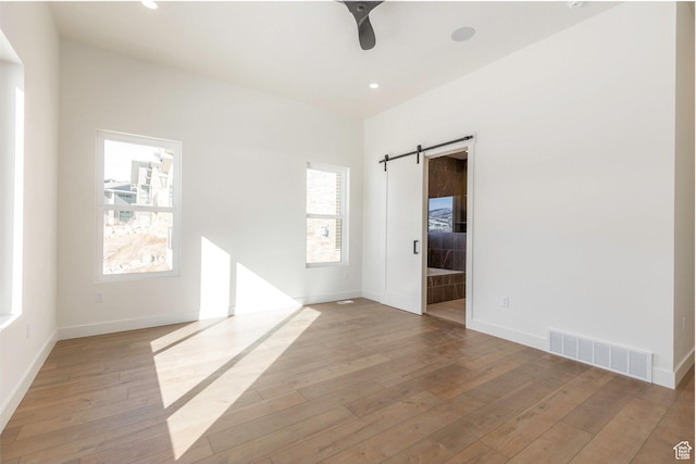 496 E Kayak Dr Unit 306, Hideout, UT 84036 - empty room with a barn door, baseboards, visible vents, and light wood-style flooring