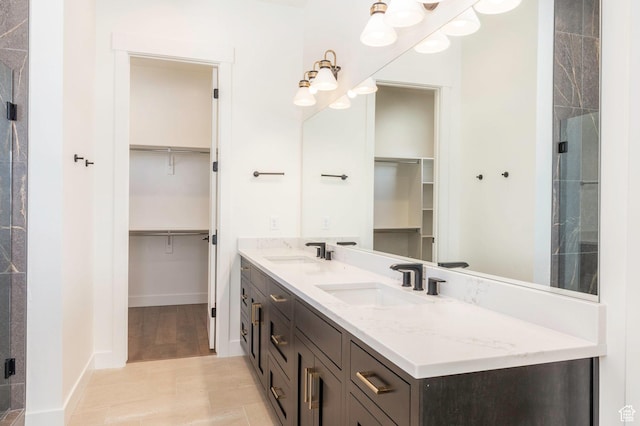 496 E Kayak Dr Unit 306, Hideout, UT 84036 - bathroom with a walk in closet, double vanity, baseboards, and a sink