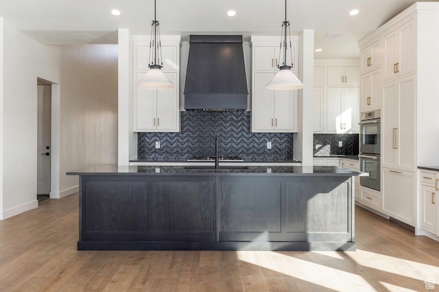 496 E Kayak Dr Unit 306, Hideout, UT 84036 - kitchen with stainless steel double oven, dark countertops, wood finished floors, decorative backsplash, and custom exhaust hood