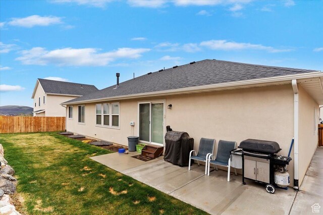 816 E Clover Way, Morgan, UT 84050 - rear view of house featuring fence, a shingled roof, stucco siding, a patio area, and a lawn