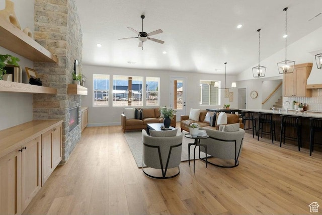 48 N Meadow Dr, Pine Valley, UT 84781 - living room with light wood finished floors, lofted ceiling, a ceiling fan, stairs, and a stone fireplace