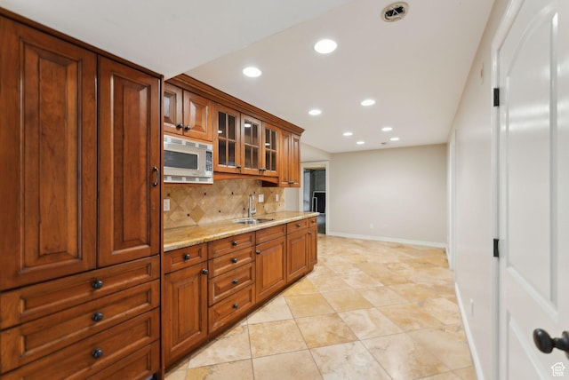 6391 S Shenandoah Park Ave E, Salt Lake City, UT 84121 - kitchen with a sink, stainless steel microwave, tasteful backsplash, baseboards, and recessed lighting