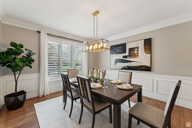 6391 S Shenandoah Park Ave E, Salt Lake City, UT 84121 - dining area featuring wood-type flooring, a chandelier, a wainscoted wall, and ornamental molding