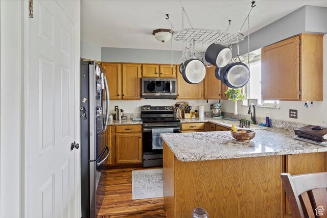 6241 S Barton Park Dr, West Jordan, UT 84081 - kitchen featuring light stone counters, wood finished floors, a sink, a peninsula, and appliances with stainless steel finishes