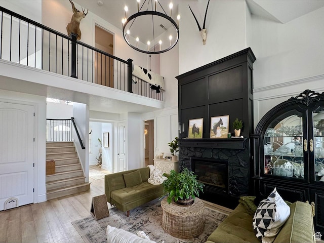 1844 W Heritage Ranch Dr N, Farr West, UT 84404 - living room with a decorative wall, a stone fireplace, a high ceiling, and stairs